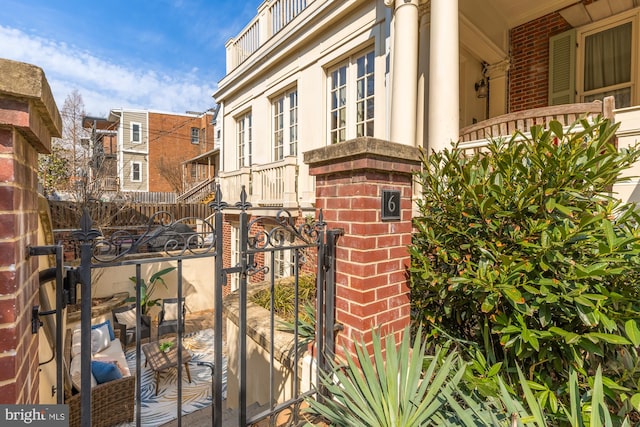 view of gate featuring a residential view, covered porch, and fence