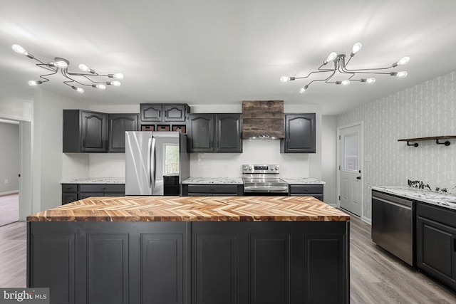 246 Locust Ln, Edinburg, VA 22824 - kitchen with butcher block countertops, light wood-type flooring, an inviting chandelier, a kitchen island, and appliances with stainless steel finishes