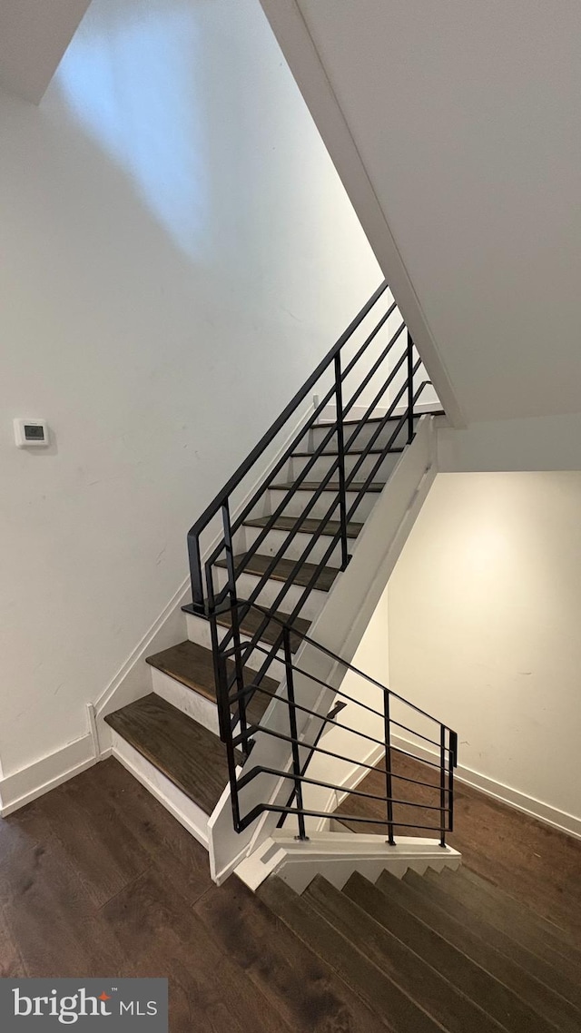 stairway featuring baseboards and wood finished floors