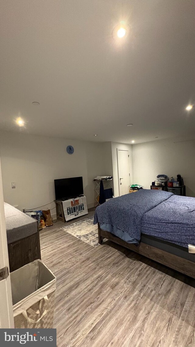 bedroom with recessed lighting and wood finished floors