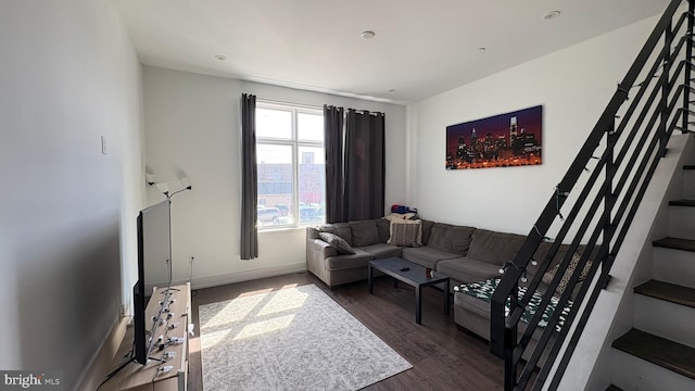 living area featuring baseboards, stairs, and dark wood-type flooring