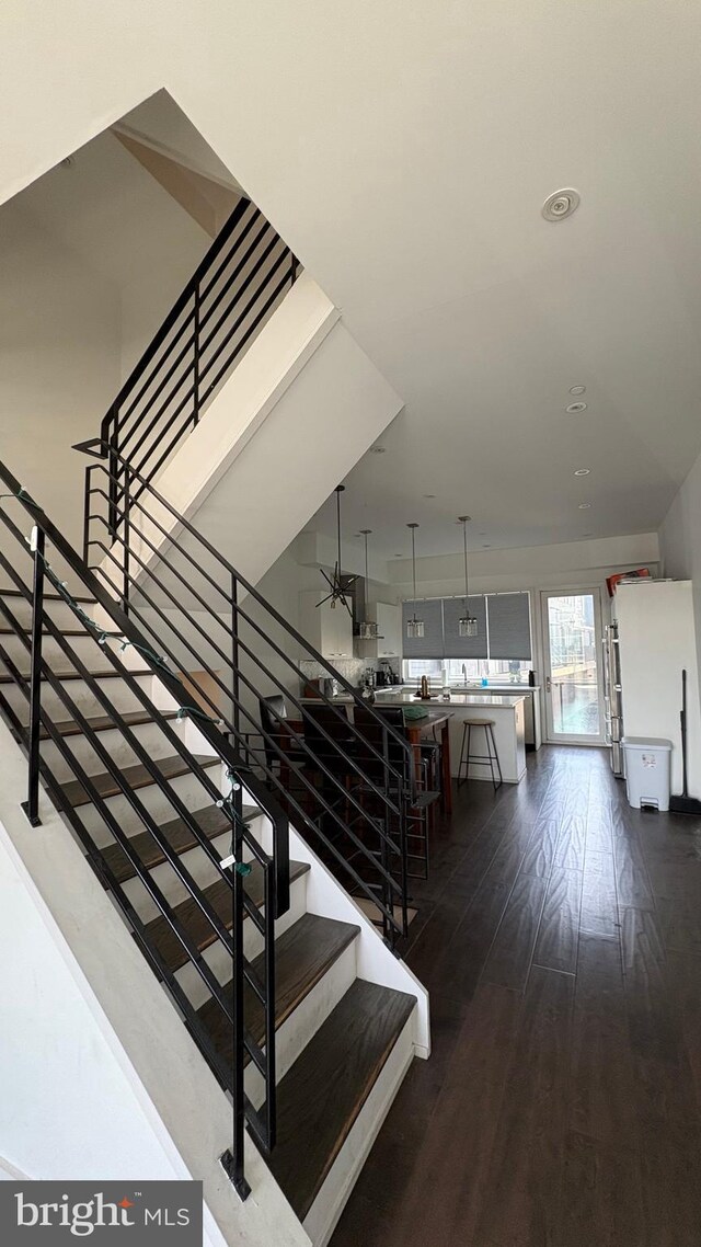 stairs with wood finished floors and a ceiling fan