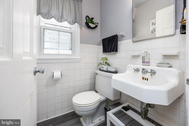 26547 Old State Rd, Crisfield, MD 21817 - bathroom featuring tile walls, toilet, a sink, wood finished floors, and a wainscoted wall