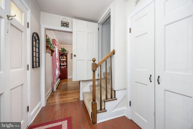 26547 Old State Rd, Crisfield, MD 21817 - foyer featuring baseboards, brick patterned flooring, stairs, and a baseboard heating unit