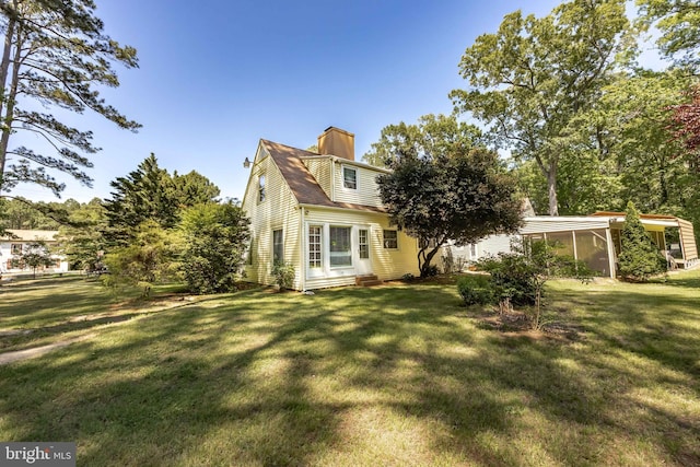 26547 Old State Rd, Crisfield, MD 21817 - rear view of property featuring a chimney, a lawn, and a sunroom