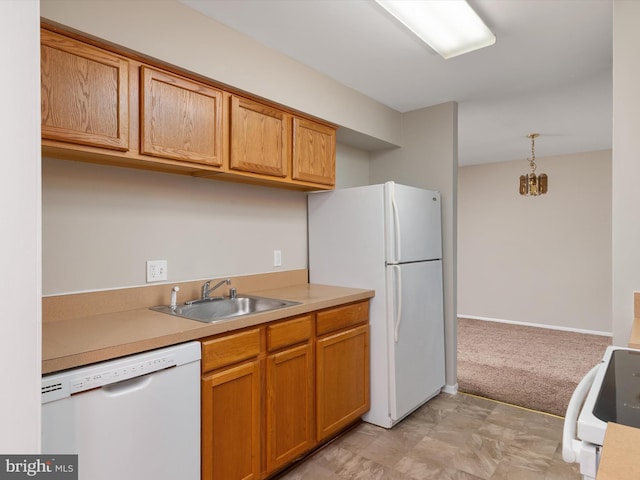 kitchen with brown cabinets, light countertops, a sink, white appliances, and pendant lighting