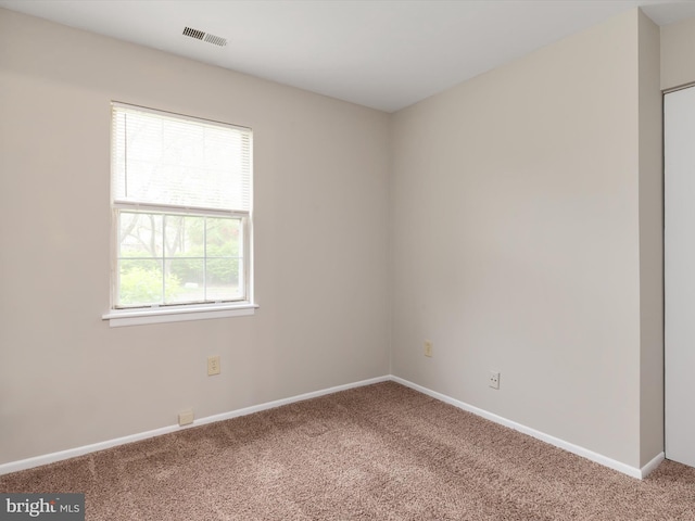 carpeted spare room with baseboards and visible vents