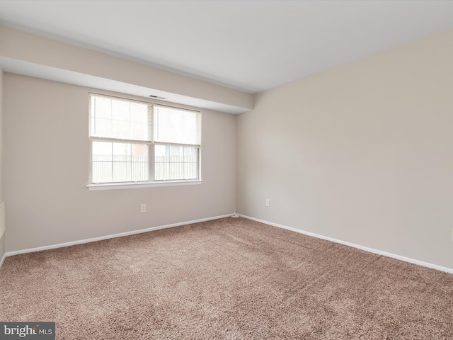 spare room with carpet and baseboards