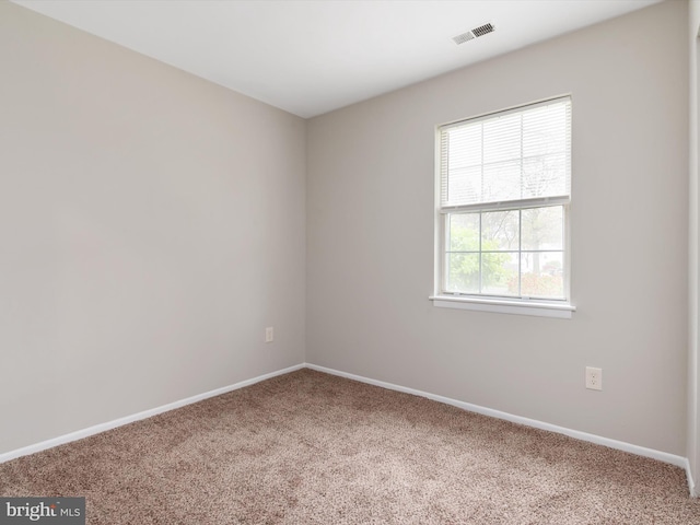 spare room featuring baseboards, carpet flooring, and visible vents