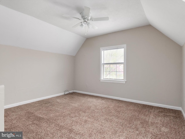 additional living space with lofted ceiling, carpet floors, a ceiling fan, and baseboards