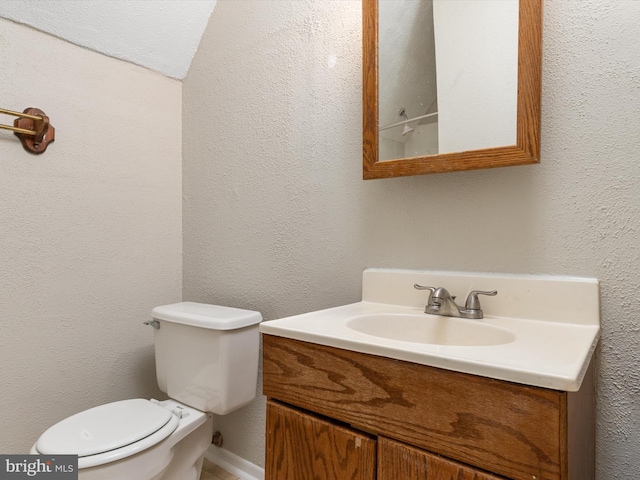half bathroom featuring toilet and vanity
