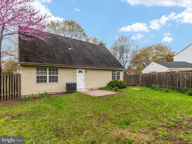 back of property featuring a yard, central AC, a patio, and a fenced backyard