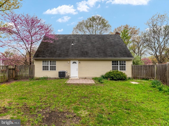 back of property featuring a fenced backyard, a yard, central air condition unit, and a patio area