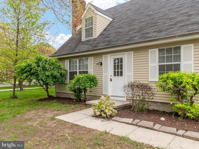 property entrance with a shingled roof and a chimney