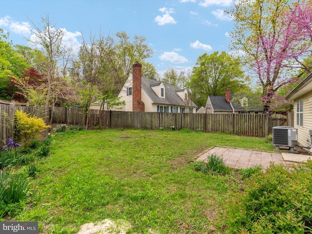 view of yard featuring a fenced backyard, central AC, and a patio