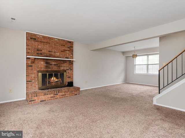 unfurnished living room with a brick fireplace, baseboards, carpet, and stairs