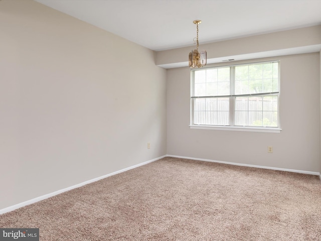 unfurnished room featuring baseboards, carpet flooring, and a chandelier