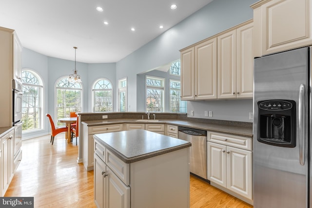 kitchen featuring a peninsula, dark countertops, recessed lighting, stainless steel appliances, and light wood-style floors
