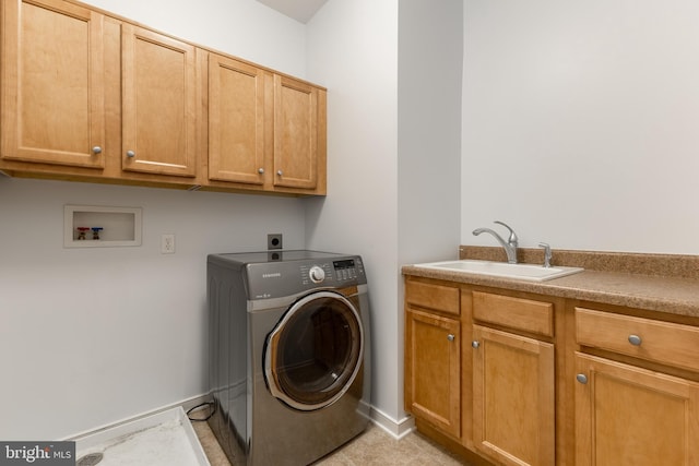 laundry room with a sink, cabinet space, washer / dryer, and baseboards