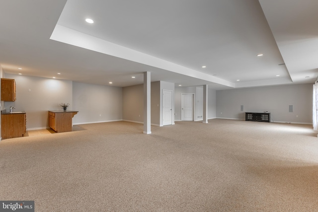 finished below grade area with wet bar, a sink, baseboards, and recessed lighting