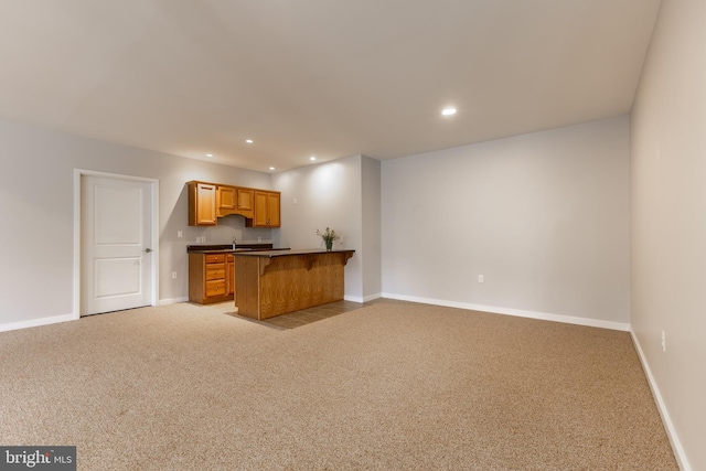 kitchen featuring baseboards, light colored carpet, recessed lighting, and open floor plan