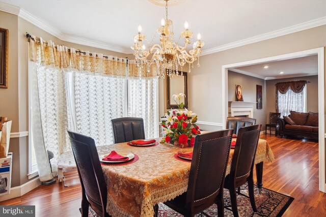 6301 Bradford Ct, Frederick, MD 21701 - dining room with baseboards, a notable chandelier, a fireplace, crown molding, and wood finished floors