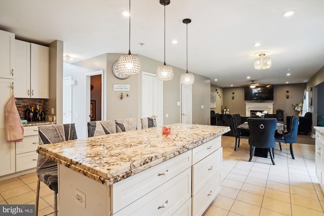 6301 Bradford Ct, Frederick, MD 21701 - kitchen with tasteful backsplash, light tile patterned floors, a center island, decorative light fixtures, and a breakfast bar area