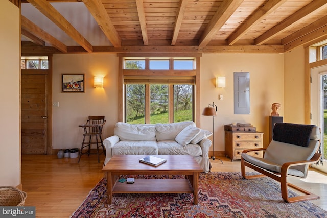 living area featuring light wood finished floors, beam ceiling, electric panel, and wood ceiling