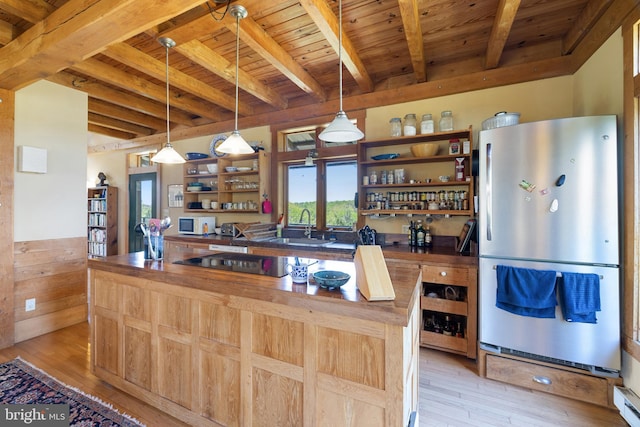 kitchen featuring freestanding refrigerator, open shelves, beamed ceiling, wooden ceiling, and a sink