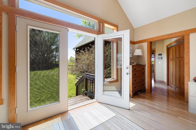 doorway to outside featuring light wood finished floors and lofted ceiling