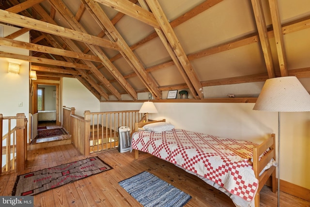 bedroom with wood-type flooring and lofted ceiling with beams