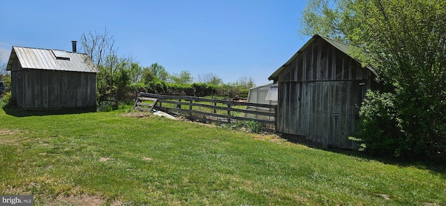 view of yard with fence and an outbuilding