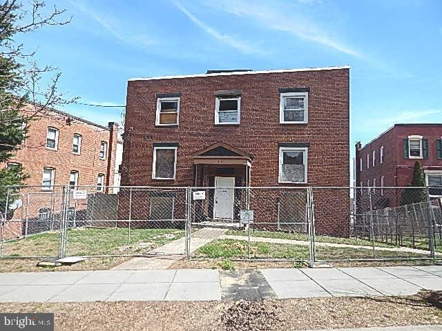 view of front facade with a gate, brick siding, and a fenced front yard