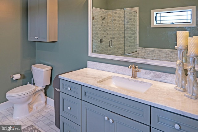 bathroom with vanity, toilet, baseboards, a shower stall, and marble finish floor