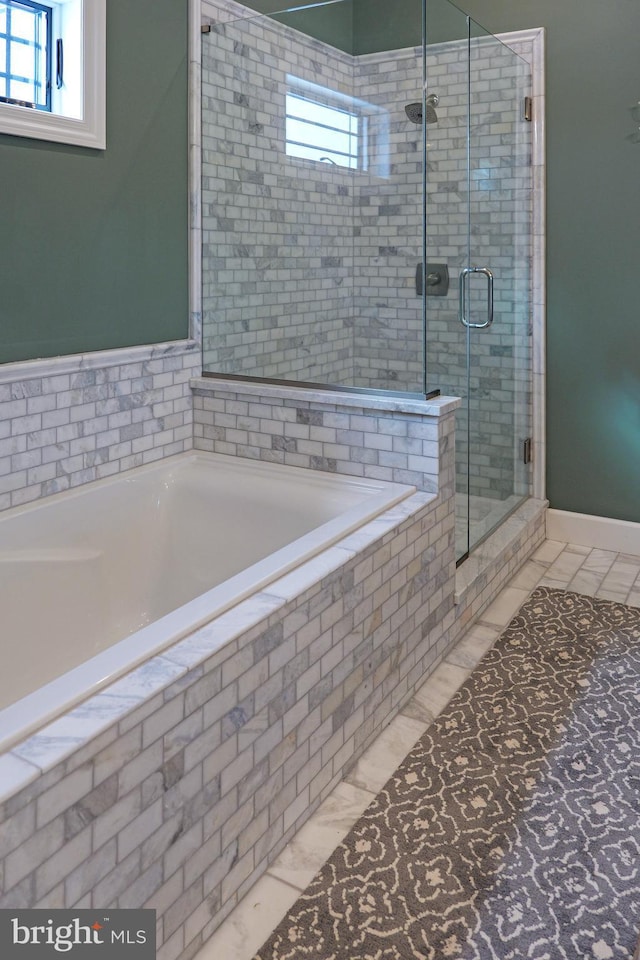 full bathroom featuring a garden tub, a healthy amount of sunlight, and a stall shower