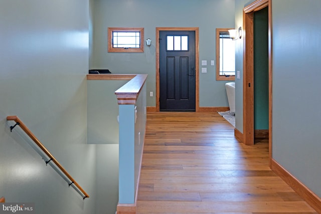 entryway with light wood finished floors and baseboards