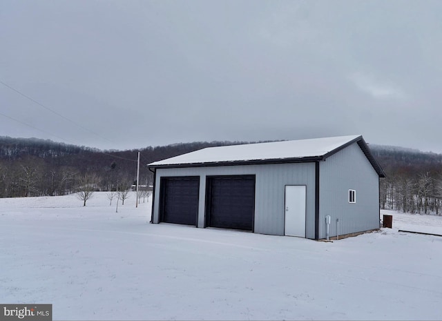 snow covered garage with a detached garage
