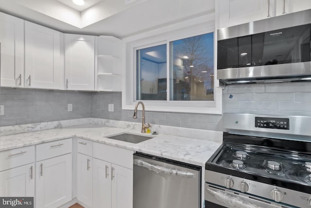 kitchen featuring a sink, white cabinets, appliances with stainless steel finishes, and tasteful backsplash