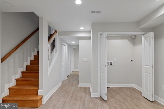 interior space featuring light wood-type flooring, baseboards, stairs, and visible vents