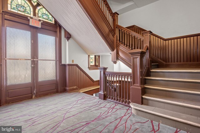 336 7th St N, Lebanon, PA 17042 - staircase with french doors, lofted ceiling, carpet flooring, and wainscoting