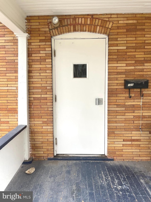 doorway to property with brick siding