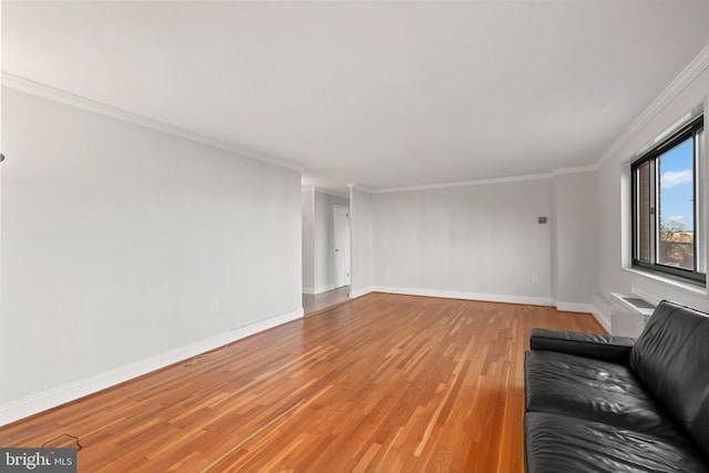 unfurnished living room featuring baseboards, a wall unit AC, light wood-style flooring, and ornamental molding