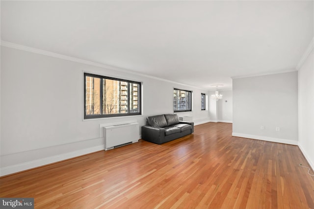 unfurnished room featuring light wood finished floors, radiator, a notable chandelier, and baseboards
