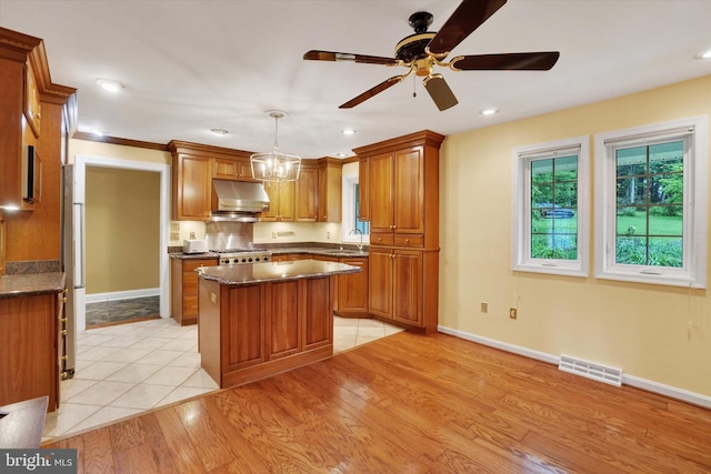 6 Deer Haven Ln, White Hall, MD 21161 - kitchen with under cabinet range hood, brown cabinetry, a center island, and recessed lighting