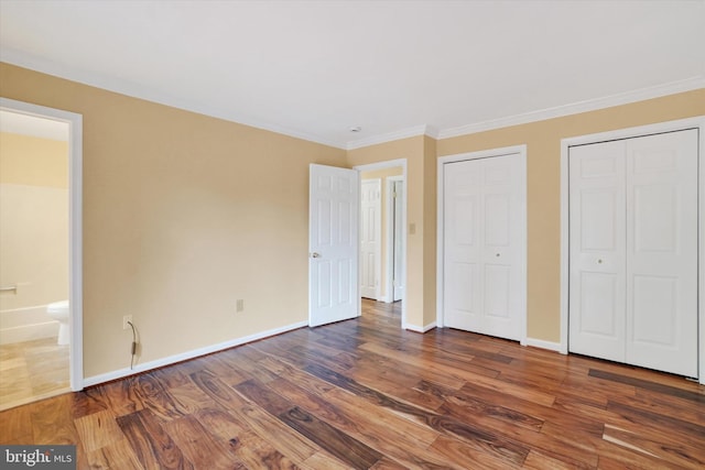 6 Deer Haven Ln, White Hall, MD 21161 - unfurnished bedroom with multiple closets, wood finished floors, crown molding, and ensuite bath