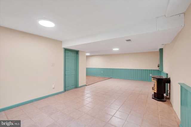6 Deer Haven Ln, White Hall, MD 21161 - finished below grade area featuring a wood stove, a wainscoted wall, and light tile patterned flooring