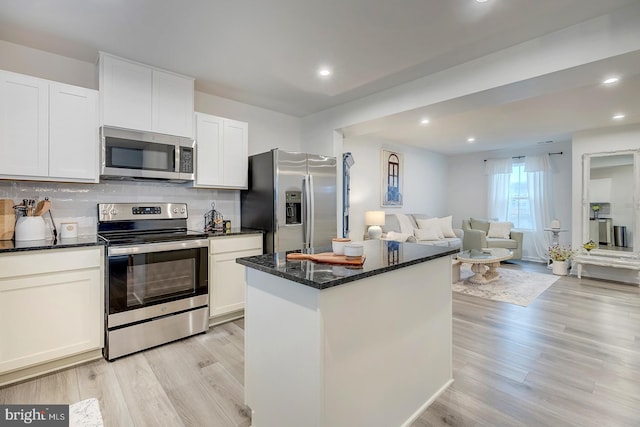 12086 Geyer Ave, Milford, DE 19963 - kitchen with tasteful backsplash, appliances with stainless steel finishes, a center island, white cabinets, and light wood-style floors