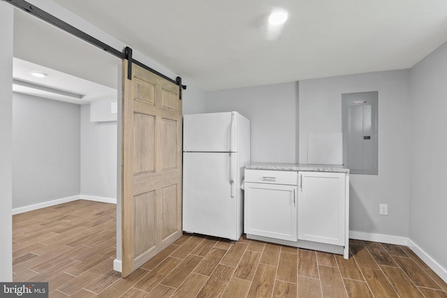 2804 Myrtle Ave NE, Washington, DC 20018 - kitchen with a barn door, electric panel, baseboards, freestanding refrigerator, and wood finished floors