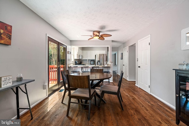 dining space featuring dark wood-style flooring, baseboards, and a ceiling fan