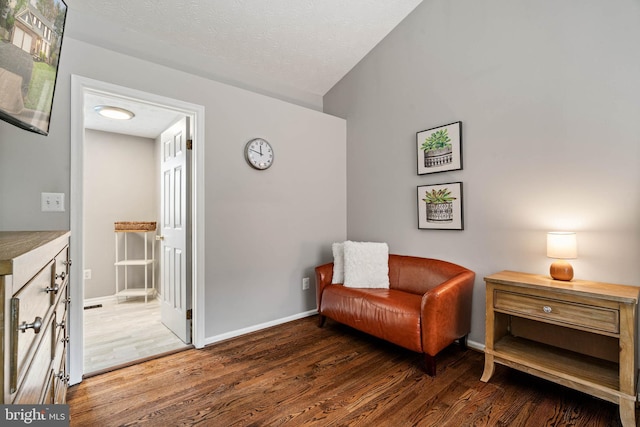 living area with a textured ceiling, wood finished floors, and baseboards